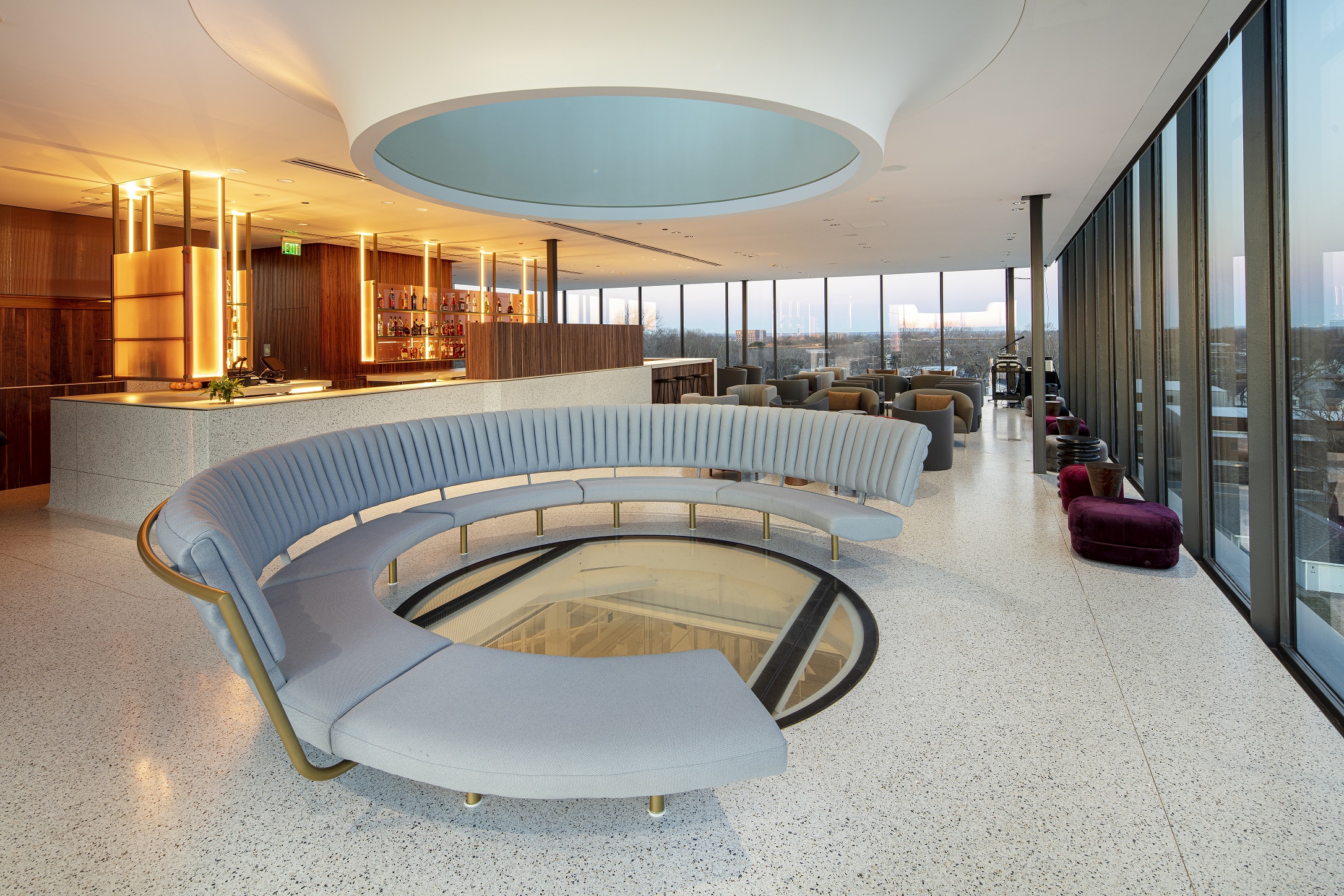 Interior of white room with floor to ceiling windows and large round couch