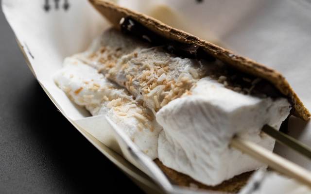 a marshmallow on a skewer with a graham cracker in a basket