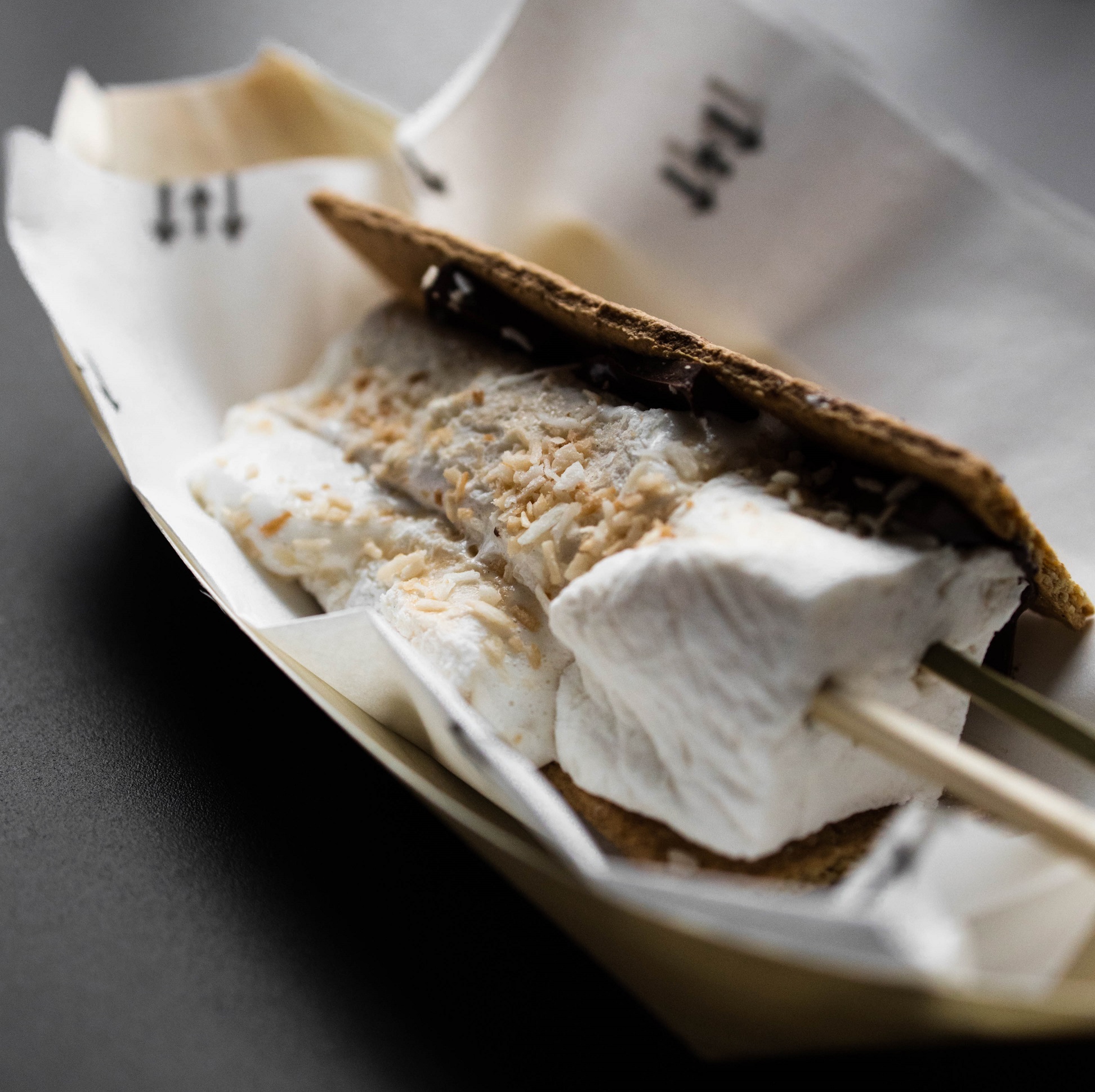 a marshmallow on a skewer with a graham cracker in a basket