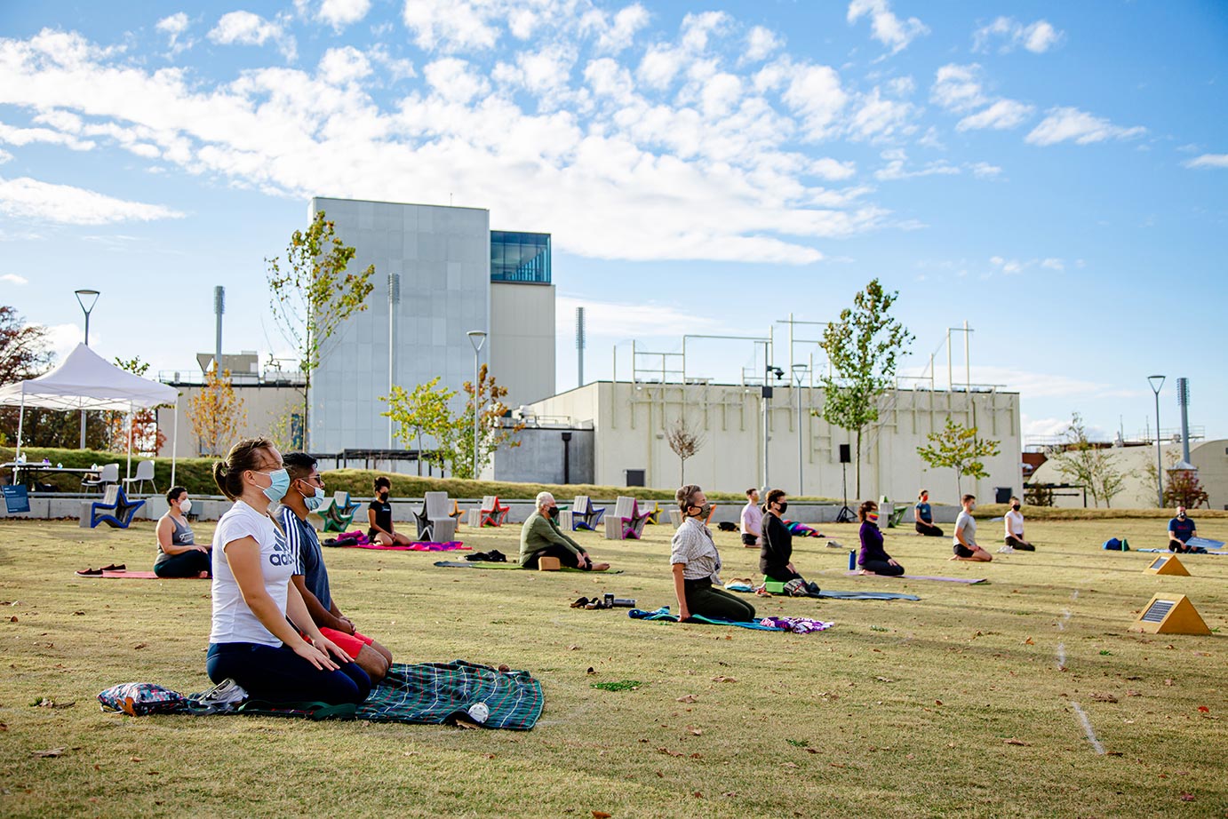 People with Masks on lawn doing yoga