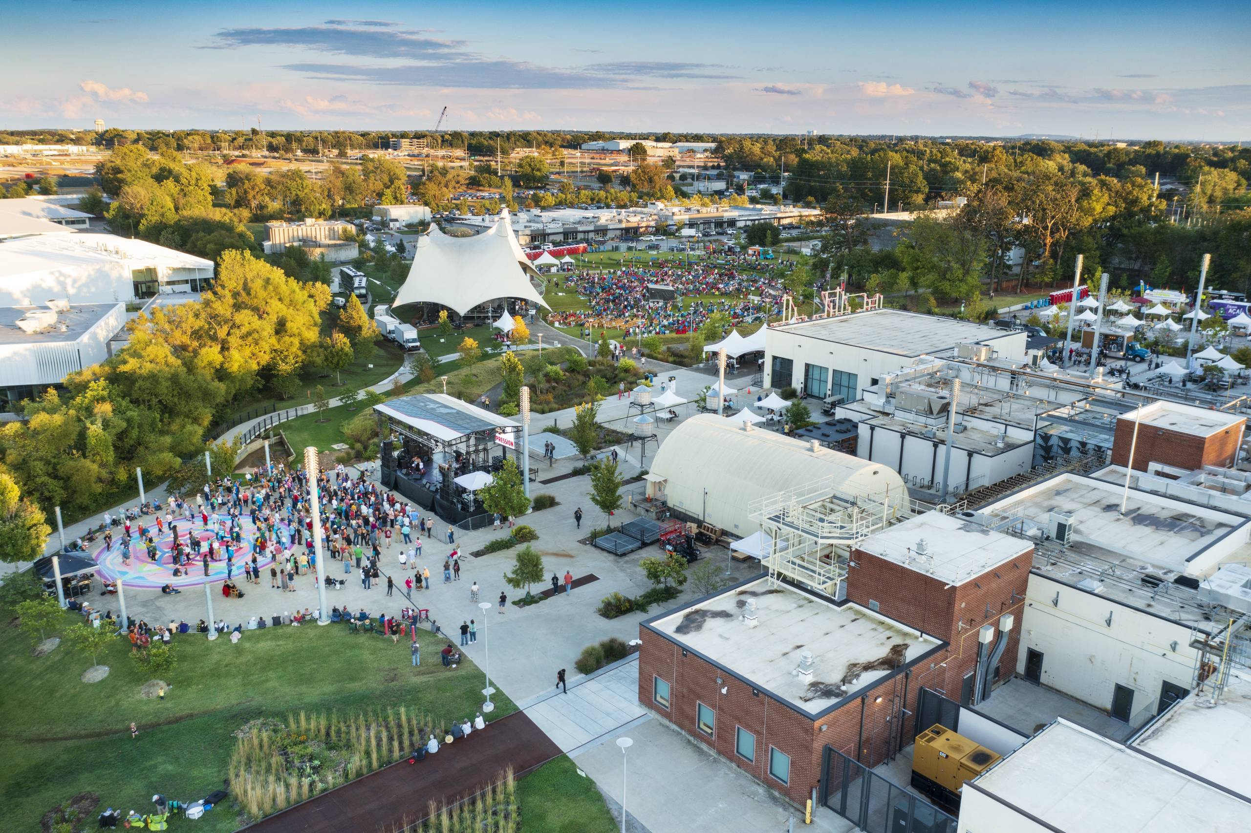 An aerial view of the Momentary and the Momentary Green featuring a canopy tent for performances and people listening to music.