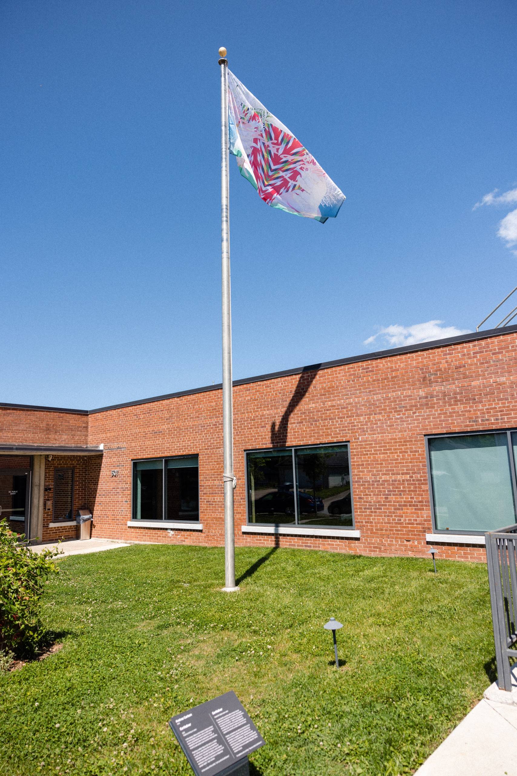 an outside shot of the momentary from e street featuring a flag pole flying an artist's flag