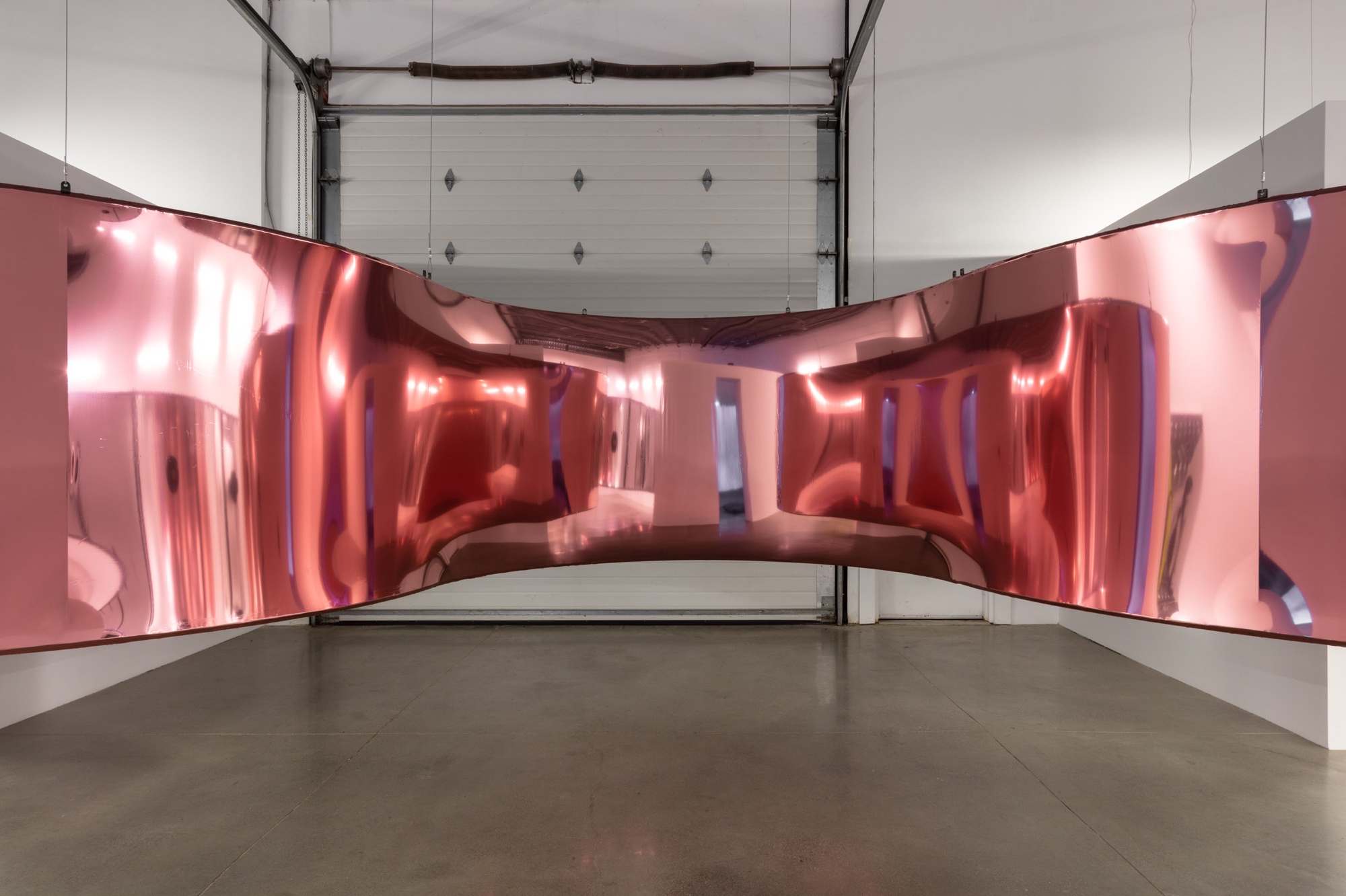 A massive, labyrinthine sound sculpture with a pulsating surface that distorts reflections.