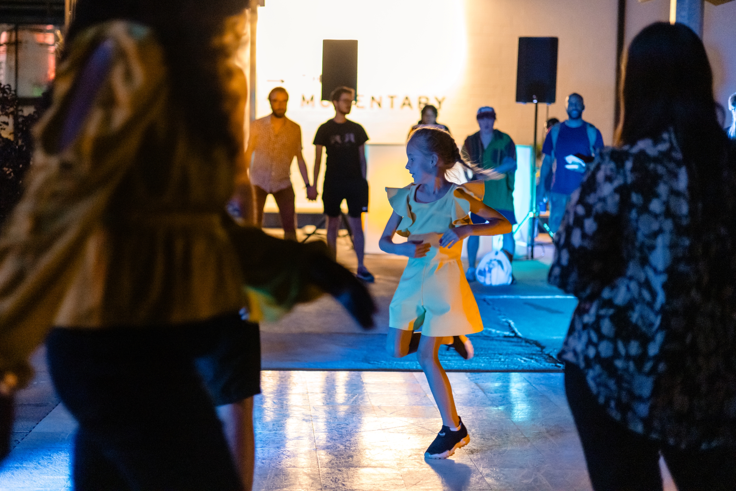 A young girl dances in a dress at an event at the Momentary