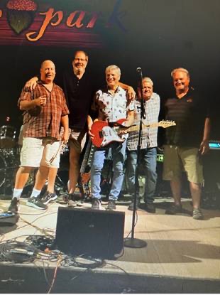 THE INTRUDERS Five men on stage with guitars and microphones, set for a musical performance.
