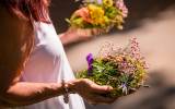 woman in a white dress holding flowers in each hand