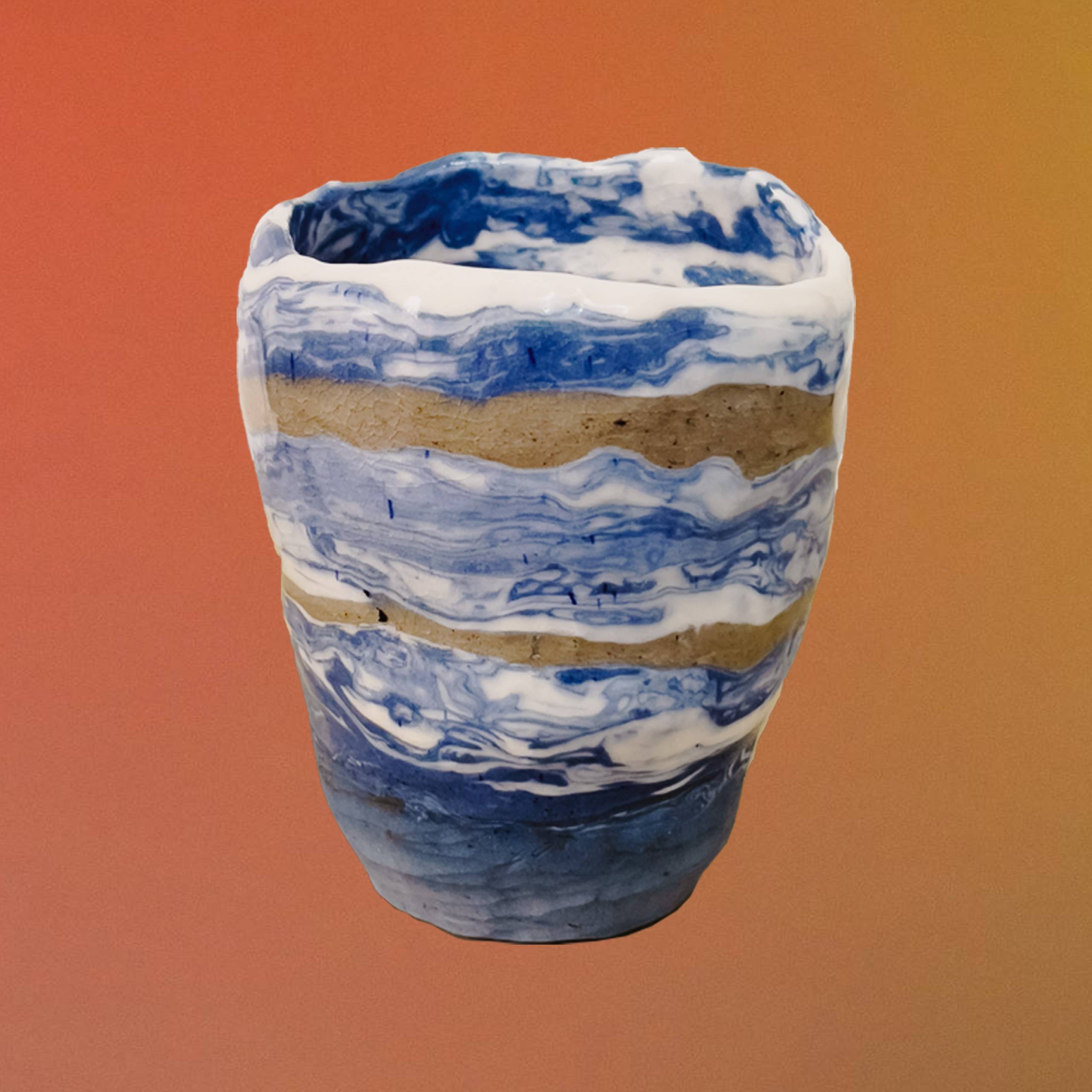 A handmade porcelain vase that was made with the Nerikomi method. The vase has a mixture of white and blue colors along with two brown tones striped across it.