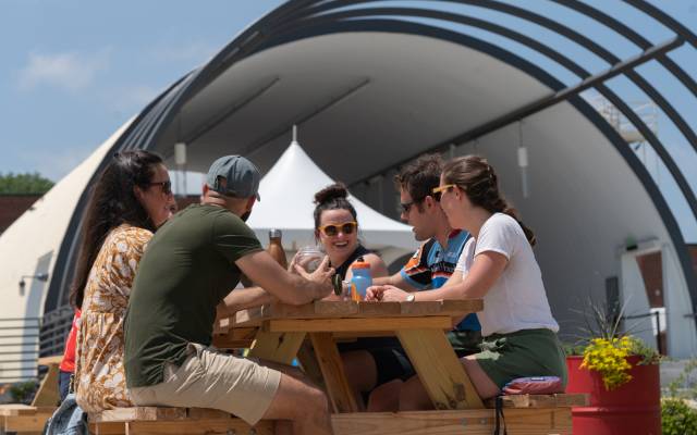 People sitting at picnic table eating