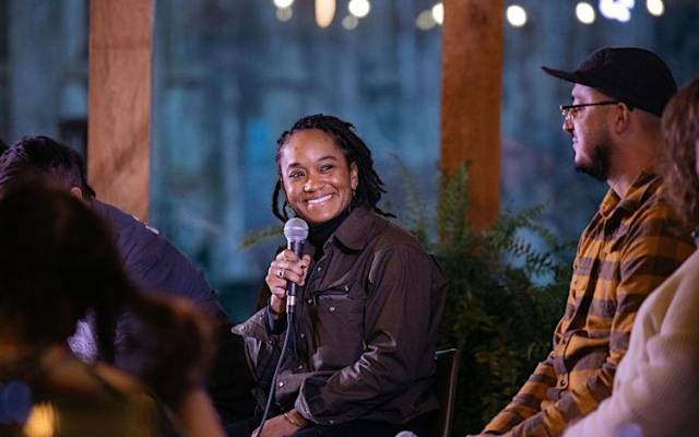 People gathered around woman with microphone smiling