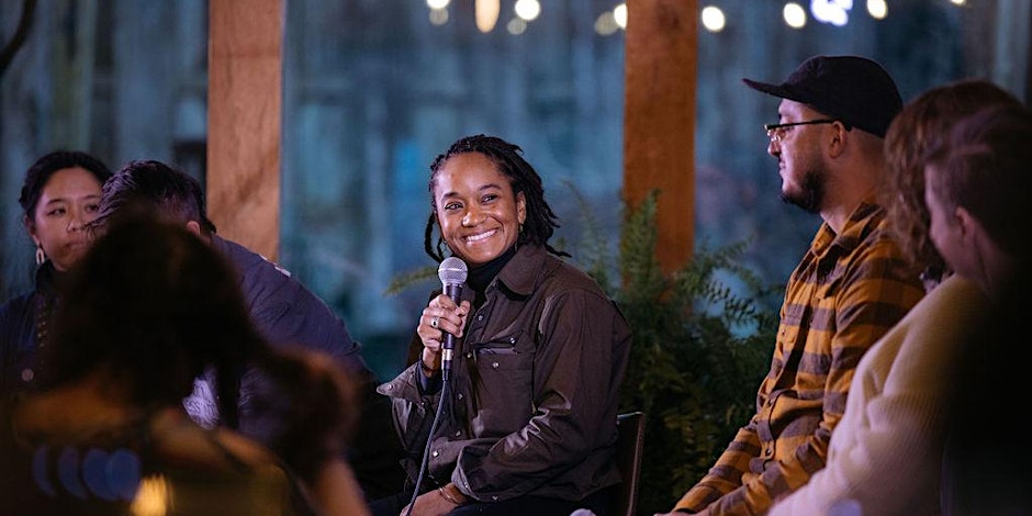 People gathered around woman with microphone smiling