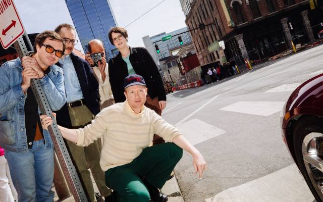 Group photo of the band Real Estate on the side of a city street