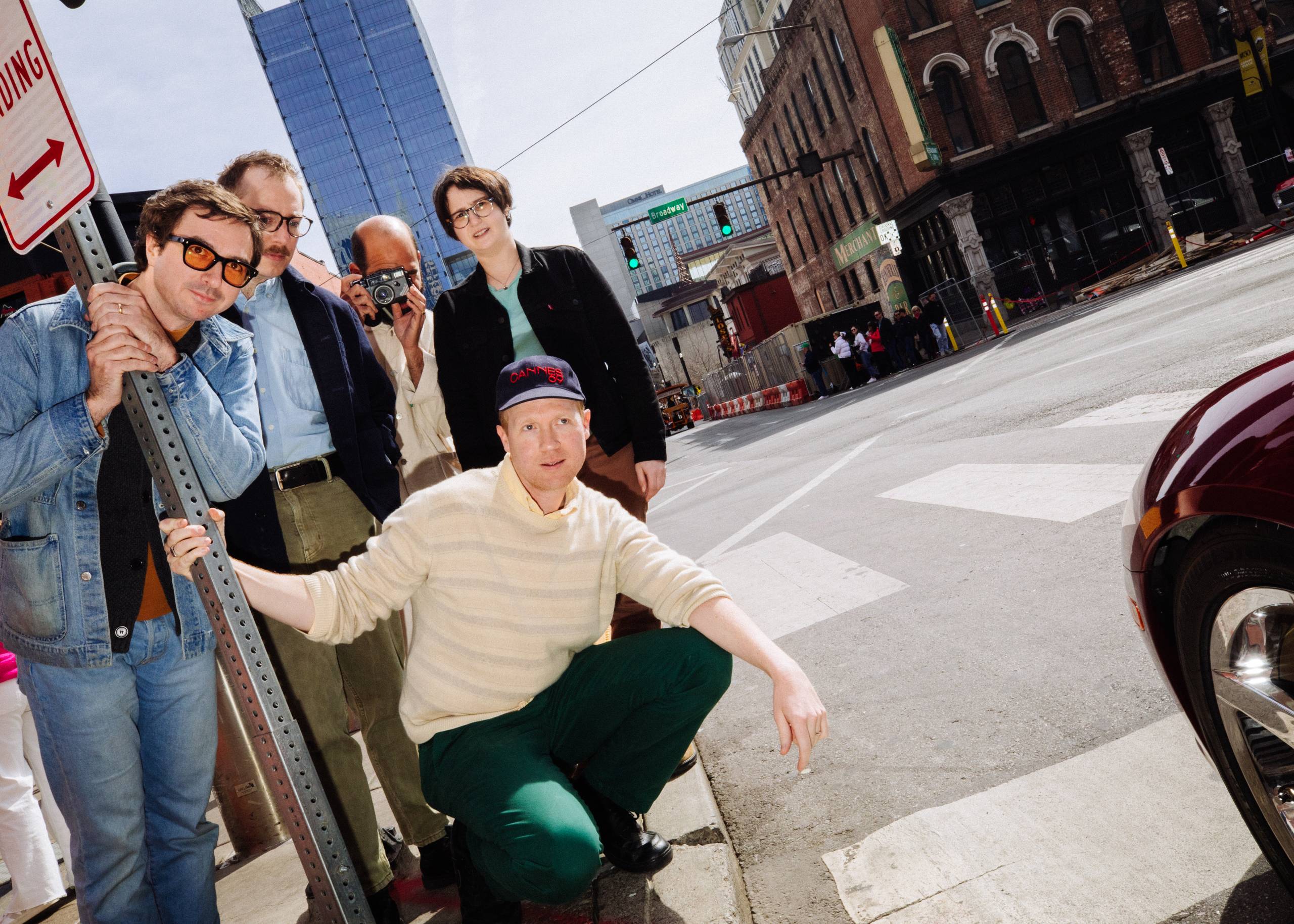 Group photo of the band Real Estate on the side of a city street