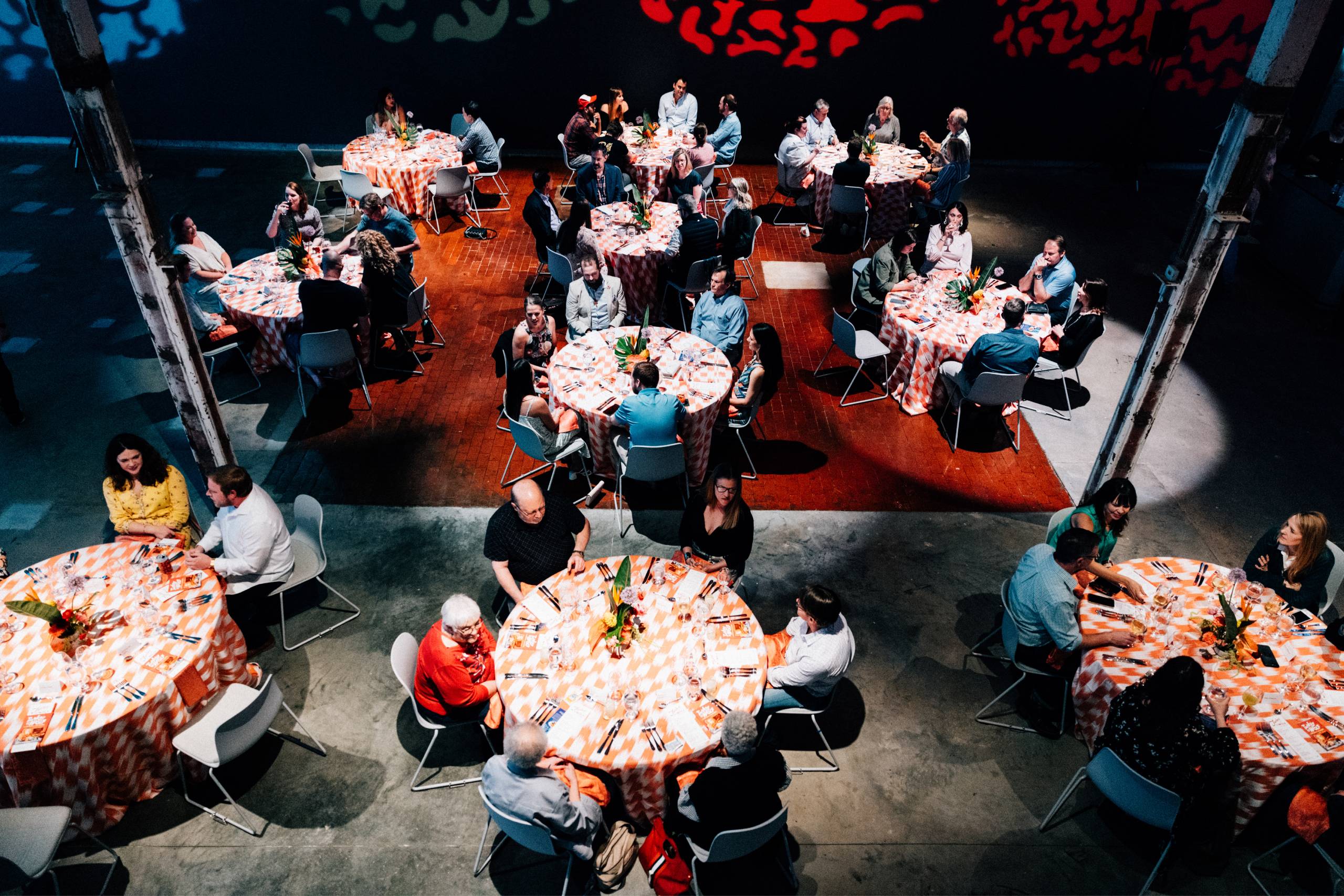 Aerial view of round tables with people eating and socializing.