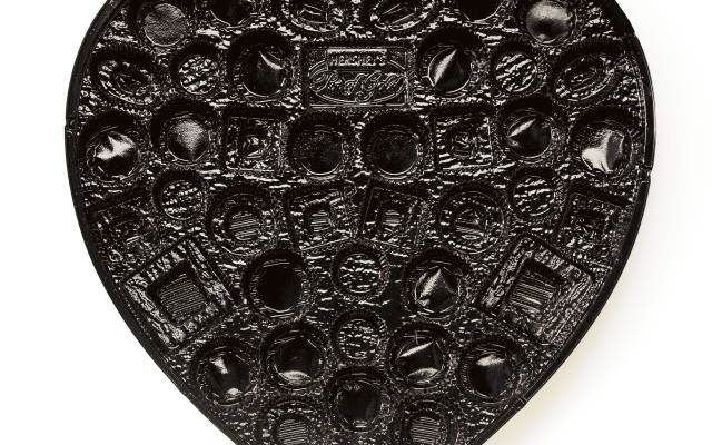 Heart-shaped plastic tray with multiple compartments for assorted chocolates or candies.