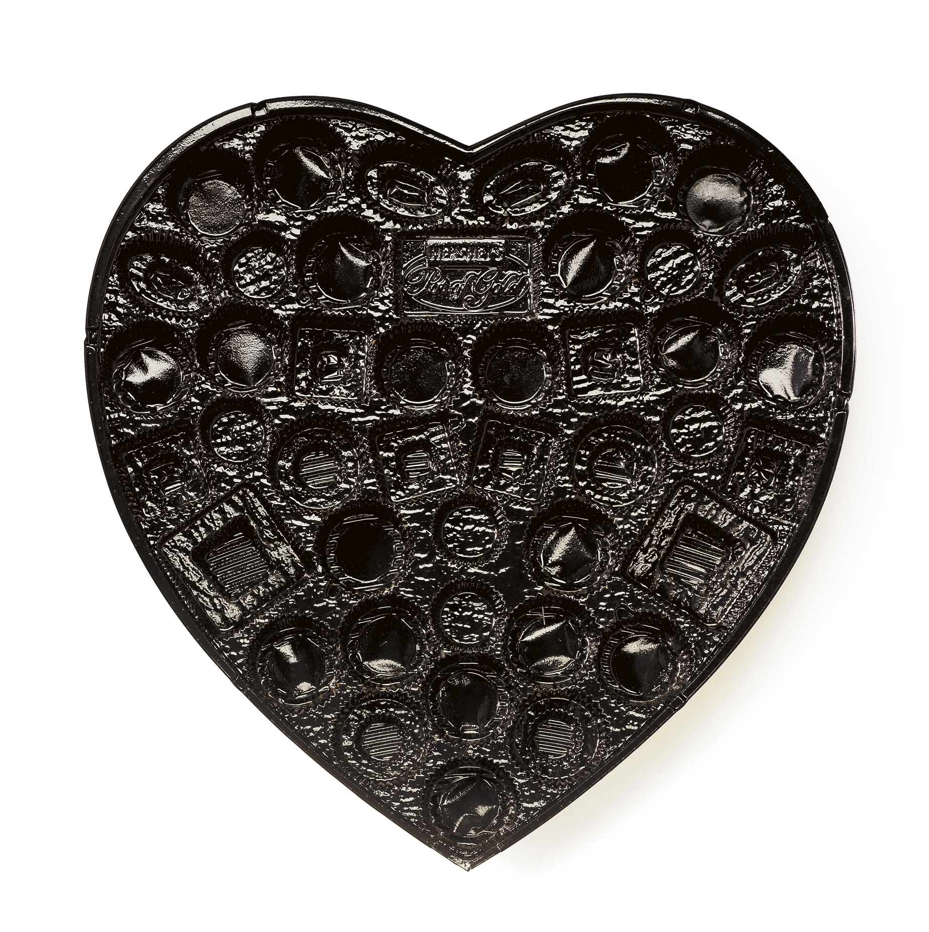 Heart-shaped plastic tray with multiple compartments for assorted chocolates or candies.